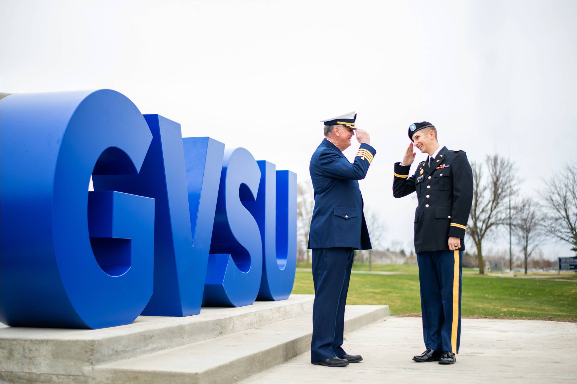 veterans saluting by GVSU block letters
